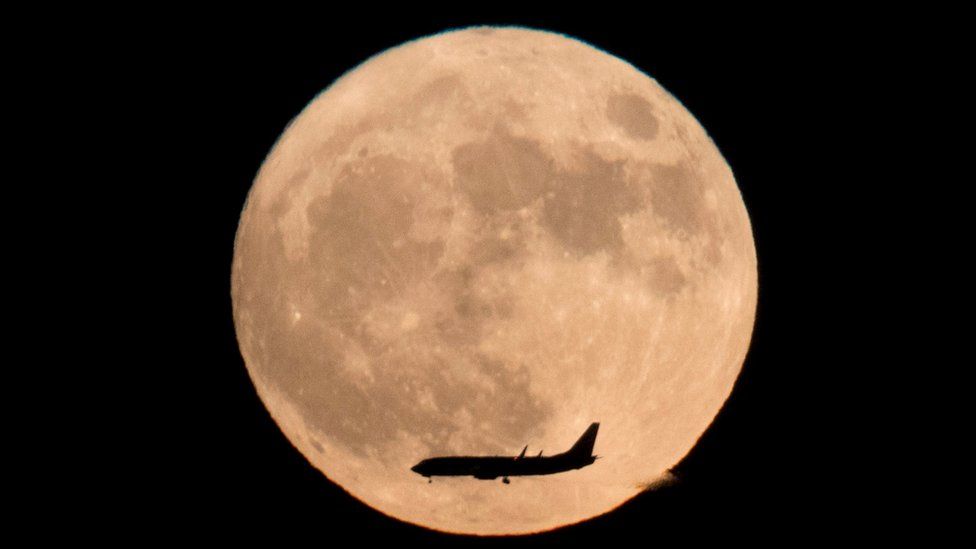a-plane-flies-across-the-moon-seen-from-beijing-china